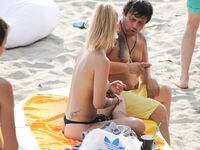 Su flor roja y una sonrisa natural en un paseo por playa topless