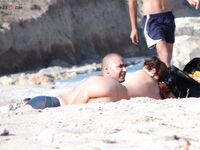 Sluneční brýle a klidná voda za opalováním na nudistické pláži
