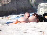 Sluneční brýle a klidná voda za opalováním na nudistické pláži