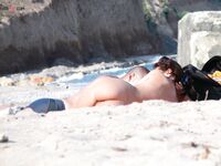Sluneční brýle a klidná voda za opalováním na nudistické pláži