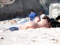 Sluneční brýle a klidná voda za opalováním na nudistické pláži