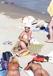 White Head Wrap and Striped Towels on a Sandy Nude Sunbathing Scene