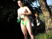 Two Women Talk Beside Calm Water on a Rocky Nudist Shore