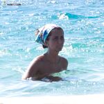 Book Open Nearby as Two Stand at a Rocky Mediterranean Shore