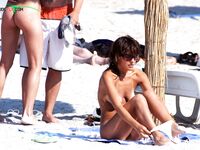 Pelo mojado y aletas tras un chapuzón al borde de una playa nudista soleada