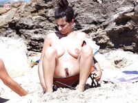 Fabric in Her Hands Beside a Towel on a Rocky Clothing-Optional Coast