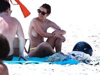 Nudists Wade Through Shallow Seawater at the Shoreline