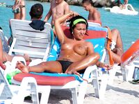 Gold Necklace and Striped Lounger Topless Sunbathing by Calm Water