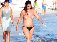 Topless procházka po břehu s potištěnou taškou kolem plavců
