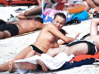 One Bare, One in Black Bikini Bottoms Wading Through Shallow Surf