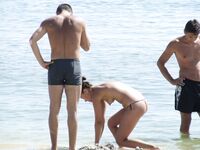 Two Nudists Chatting with a Phone on a Coastal Nude Beach