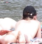 Deitada na Areia Tranquila de uma Praia Nudista Sob um Boné Preto