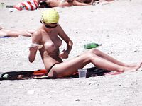 Przy otwartym morzu z papierosem na plaży nudystów