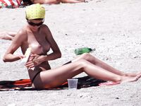 Przy otwartym morzu z papierosem na plaży nudystów