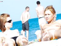 A model enjoying the intense heat of the sun in a relaxed, topless style. 5