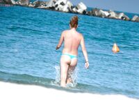 The contrast of the white sea foam against a natural, sun-kissed topless figure. 2