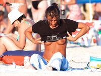 Roztažené ruce při opalování na břiše na nudistické pláži