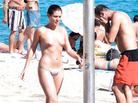 A Laughing Topless Moment on the Sand With Gear Close By