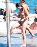 A Laughing Topless Moment on the Sand With Gear Close By