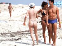 Face-Down Nude Tanning With Sand on Her Skin at the Beach