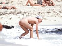 Face-Down Nude Tanning With Sand on Her Skin at the Beach