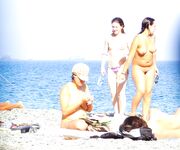 Walking Across Pebbles at a Nude Beach by Blue Sea