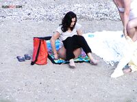 Cheveux roux et bas bleus sur une plage topless