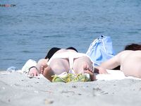 Cheveux roux et bas bleus sur une plage topless