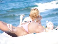 Entspannt ausgestreckt auf weißem Handtuch beim Nacktsonnenbad