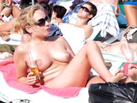 A woman enjoying the view of the waves in a relaxed topless state. 2