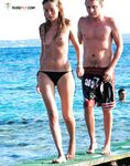 A woman enjoying the view of the waves in a relaxed topless state. 2