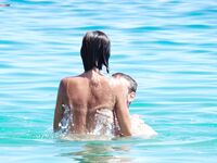 A pancia in giù sulla calda sabbia della spiaggia nudista dopo una nuotata
