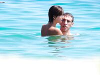 A pancia in giù sulla calda sabbia della spiaggia nudista dopo una nuotata