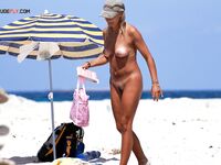 Vyrovnává se v drobných vlnkách na klidné nudistické pláži