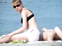 A lady enjoying a book and the warm rays in a relaxed topless fashion. 2