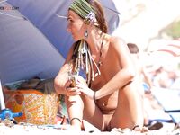 A candid moment of a lady cooling off in the surf in a classic European topless style. 2