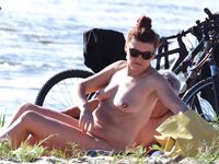A topless lady watching the waves from a quiet, elevated coastal vantage point. 2