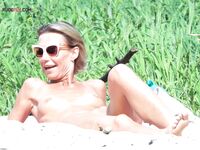 A topless lady watching the waves from a quiet, elevated coastal vantage point. 2