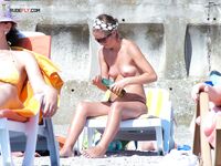 Sunscreen in Hand on a Sunny Nude Beach Lounger
