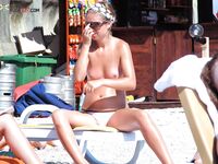 Sunscreen in Hand on a Sunny Nude Beach Lounger