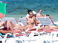 Esce topless dall'acqua bassa con slip turchese
