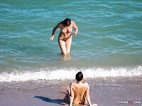 At the Water's Edge on a Nude Beach With Hills Behind