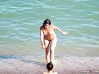 At the Water's Edge on a Nude Beach With Hills Behind