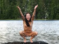 Wasser spritzen vom halb versunkenen Baumstamm im Waldsee