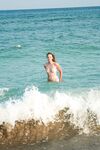 De la vague turquoise vers le sable de la plage naturiste