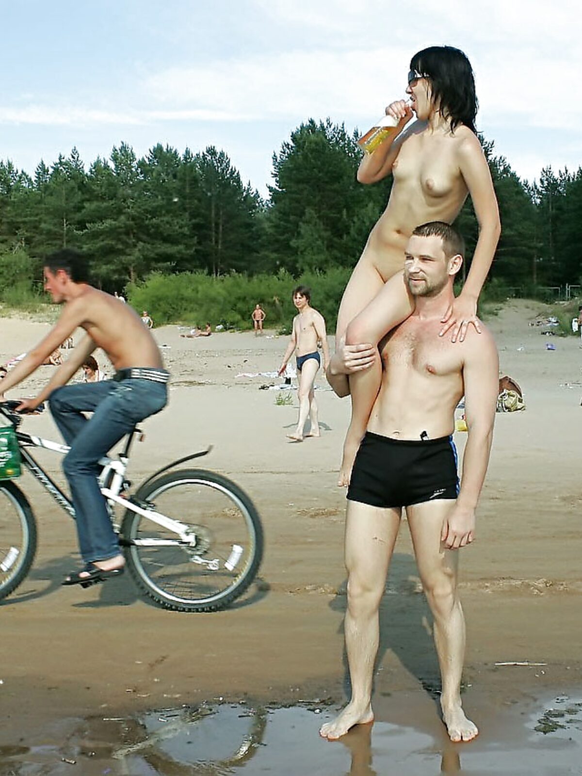 Na ramenou, zatímco cyklista přejíždí mokrým pískem album preview