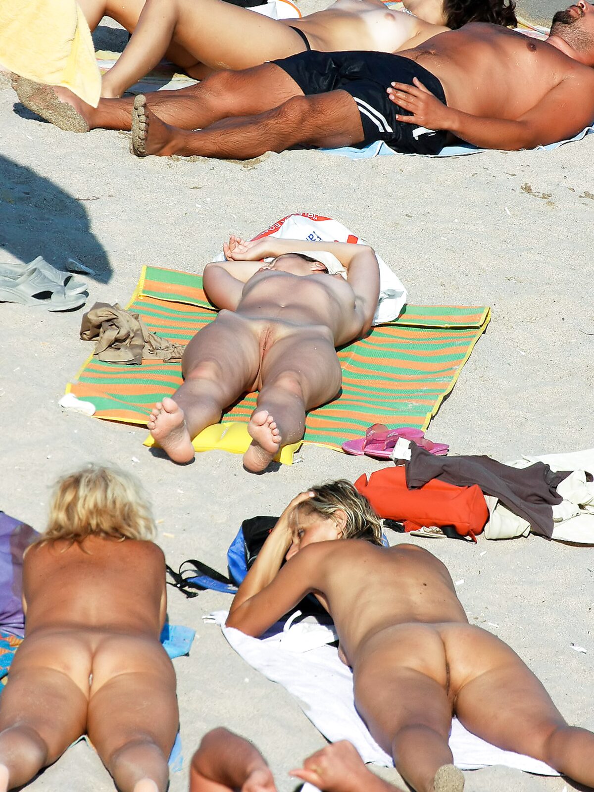 Tanned nudist hottie relaxes in the sun and enjoys a hot summer day at the beach album preview