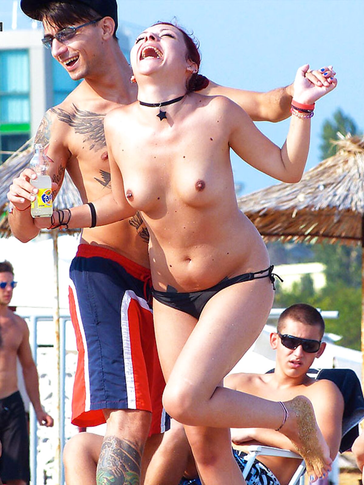 Two Adults on a Topless Beach with Thatched Umbrellas album preview
