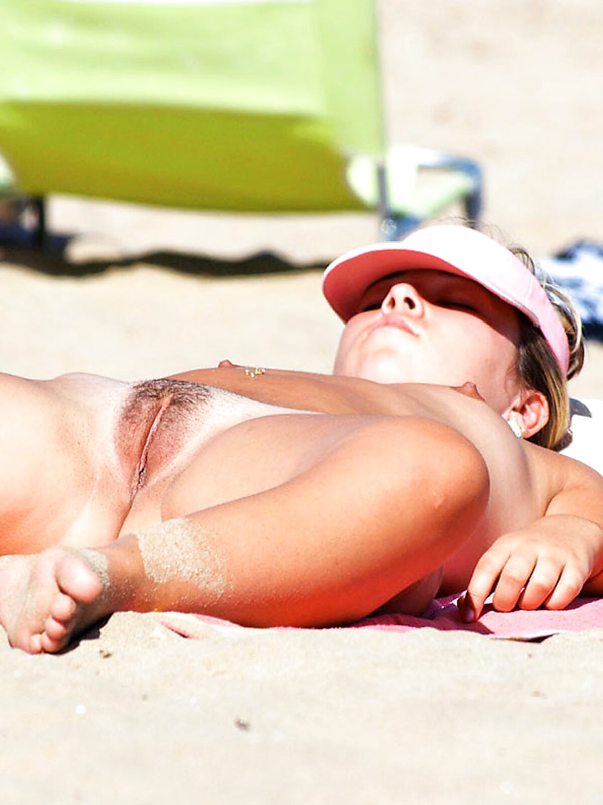 A lady enjoying the ultimate tan at a clothing-optional seaside resort. album preview
