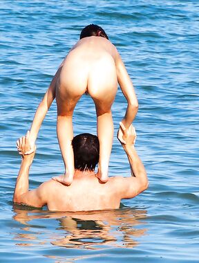The natural beauty of a lady sunbathing topless on a quiet, sunny pier.